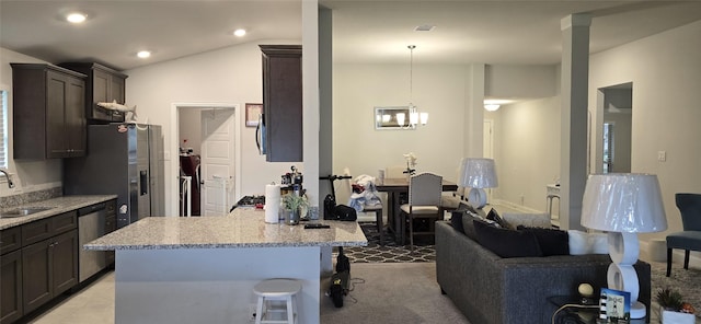 5311 New Iberia Ln, Dickinson, TX 77539 - kitchen with stainless steel appliances, a kitchen bar, dark brown cabinetry, light stone countertops, and a peninsula