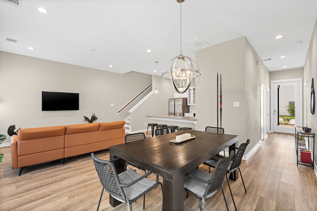 413 Stonework Oaks Ln, Houston, TX 77076 - dining room with light wood-style flooring, a chandelier, stairway, and recessed lighting