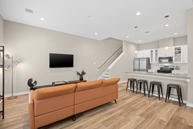 413 Stonework Oaks Ln, Houston, TX 77076 - living area featuring light wood-type flooring, recessed lighting, and stairs