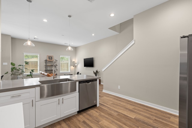 413 Stonework Oaks Ln, Houston, TX 77076 - kitchen featuring stainless steel dishwasher, wood finished floors, white cabinets, recessed lighting, and pendant lighting