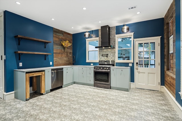 208 E 12th St, Houston, TX 77008 - kitchen featuring stainless steel appliances, wall chimney range hood, light countertops, recessed lighting, and wooden walls