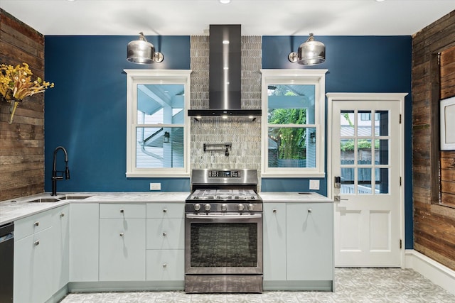 208 E 12th St, Houston, TX 77008 - kitchen with wall chimney exhaust hood, appliances with stainless steel finishes, wood walls, white cabinetry, and tasteful backsplash