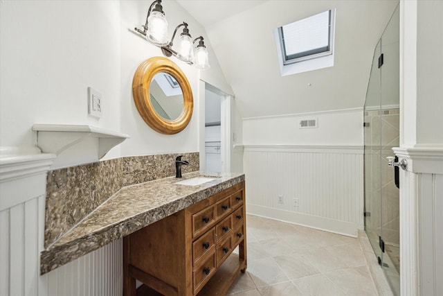 208 E 12th St, Houston, TX 77008 - full bathroom featuring a wainscoted wall, a skylight, vanity, vaulted ceiling, and tile patterned flooring