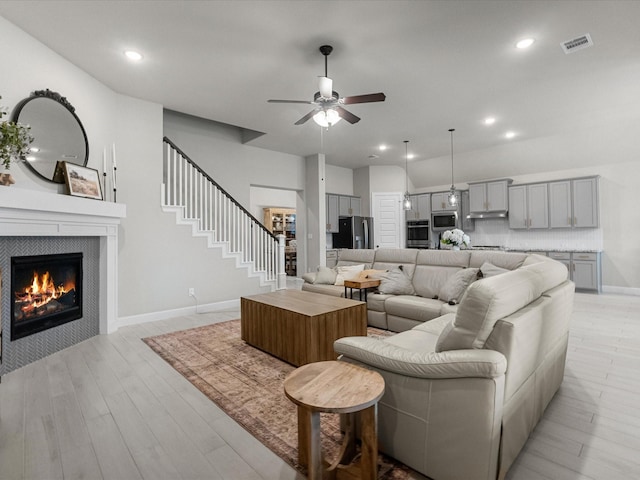 706 Westwood Dr, League City, TX 77573 - living area featuring ceiling fan, light wood-style flooring, a tile fireplace, recessed lighting, and stairs