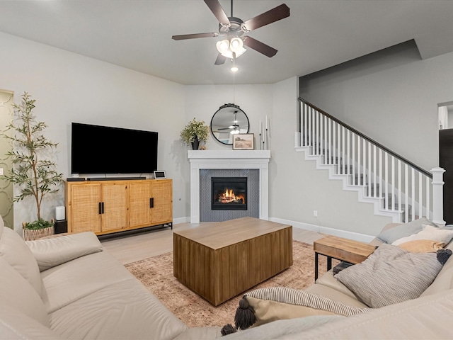 706 Westwood Dr, League City, TX 77573 - living room featuring a ceiling fan, a tiled fireplace, light wood finished floors, and stairway