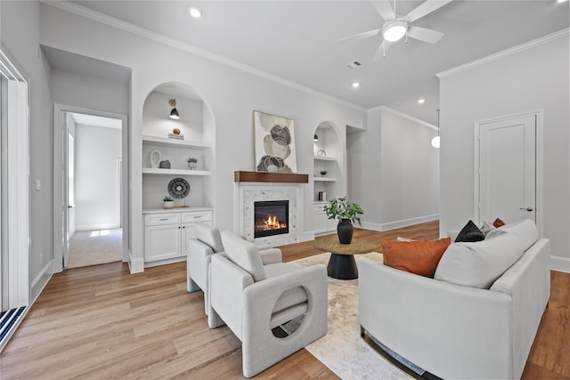 161 Pine Branch Dr, Montgomery, TX 77356 - living area with ornamental molding, built in features, ceiling fan, light wood finished floors, and a glass covered fireplace