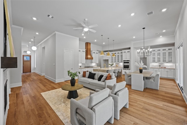 161 Pine Branch Dr, Montgomery, TX 77356 - living area featuring crown molding, a ceiling fan, a chandelier, recessed lighting, and light wood-type flooring