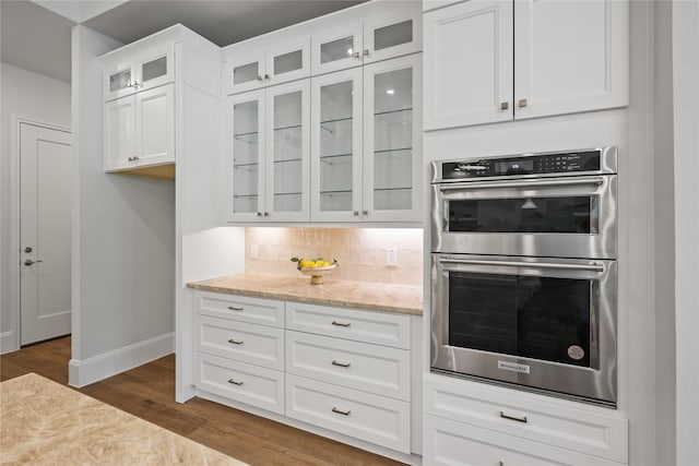 161 Pine Branch Dr, Montgomery, TX 77356 - kitchen with double oven, dark wood-style floors, light stone countertops, white cabinetry, and backsplash