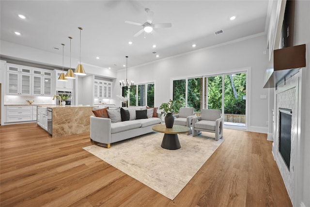 161 Pine Branch Dr, Montgomery, TX 77356 - living area with a tiled fireplace, ornamental molding, recessed lighting, light wood-style flooring, and healthy amount of natural light
