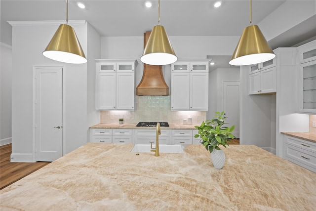 161 Pine Branch Dr, Montgomery, TX 77356 - kitchen featuring custom range hood, wood finished floors, decorative backsplash, light stone countertops, and recessed lighting