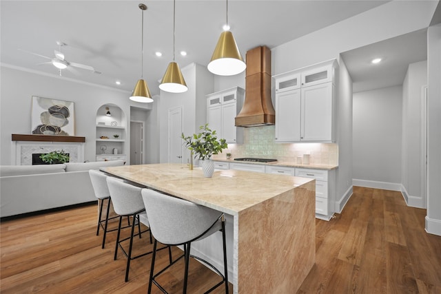 161 Pine Branch Dr, Montgomery, TX 77356 - kitchen featuring custom range hood, a ceiling fan, tasteful backsplash, white cabinetry, and a center island