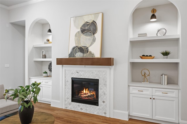 161 Pine Branch Dr, Montgomery, TX 77356 - living area featuring built in features, wood finished floors, ornamental molding, and a fireplace