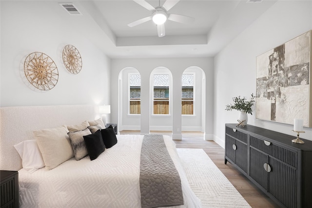 161 Pine Branch Dr, Montgomery, TX 77356 - bedroom with wood finished floors, a raised ceiling, arched walkways, and ceiling fan