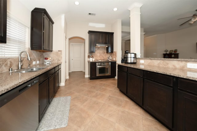 28407 Kinglet Pines Dr, Katy, TX 77494 - kitchen with appliances with stainless steel finishes, backsplash, light stone counters, a ceiling fan, and light tile patterned floors