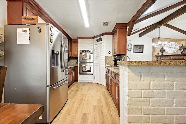 319 Shady Glade Dr, Houston, TX 77090 - kitchen featuring stainless steel appliances, light wood-style flooring, tasteful backsplash, brown cabinetry, and ornamental molding