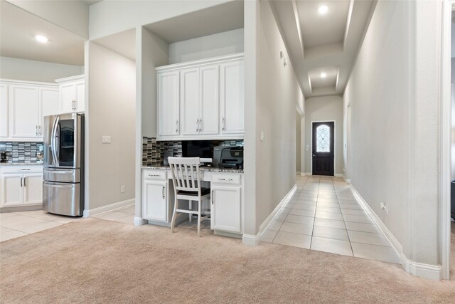 1806 Bridge Gate Ln, Katy, TX 77494 - kitchen featuring stainless steel fridge, light tile patterned floors, light colored carpet, decorative backsplash, and white cabinetry