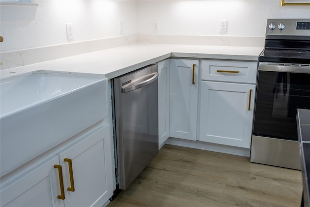 51 V Allen Ln, Coldspring, TX 77331 - kitchen featuring stainless steel appliances, light wood-type flooring, light stone countertops, and white cabinetry