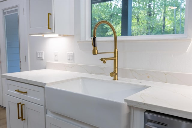 51 V Allen Ln, Coldspring, TX 77331 - kitchen with light stone countertops, dishwashing machine, and white cabinets