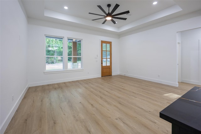 51 V Allen Ln, Coldspring, TX 77331 - unfurnished living room featuring a raised ceiling, ceiling fan, light wood-style flooring, and recessed lighting