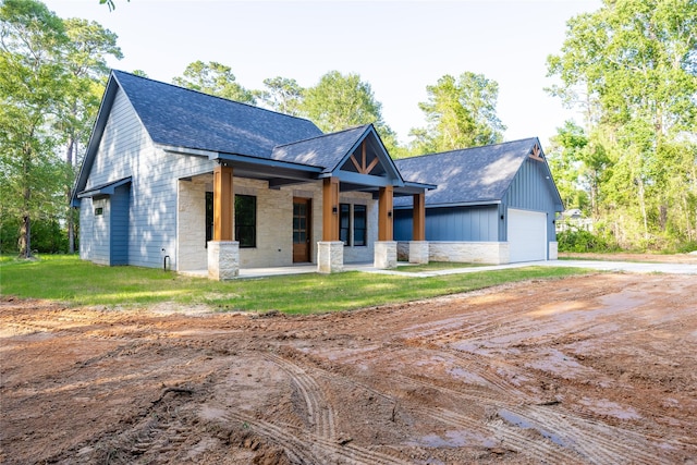 51 V Allen Ln, Coldspring, TX 77331 - view of front of house with a shingled roof, stone siding, driveway, and covered porch