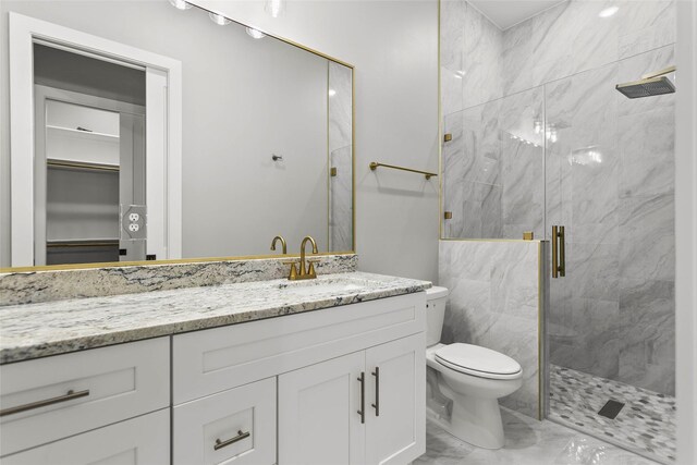 210 Hogan Ln, Hempstead, TX 77445 - bathroom featuring marble look tile flooring, a marble finish shower, vanity, and a walk in closet