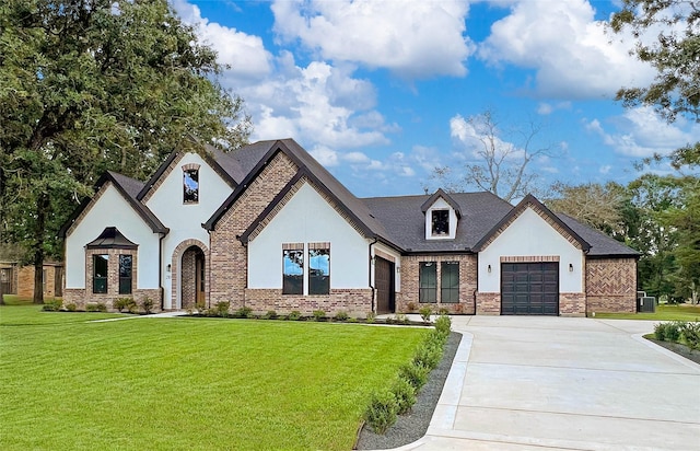 210 Hogan Ln, Hempstead, TX 77445 - french provincial home featuring stucco siding, driveway, an attached garage, and a front lawn