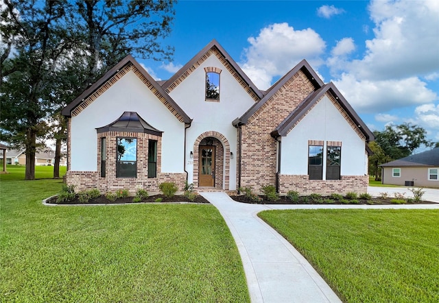 210 Hogan Ln, Hempstead, TX 77445 - french country inspired facade with brick siding, a front yard, and stucco siding