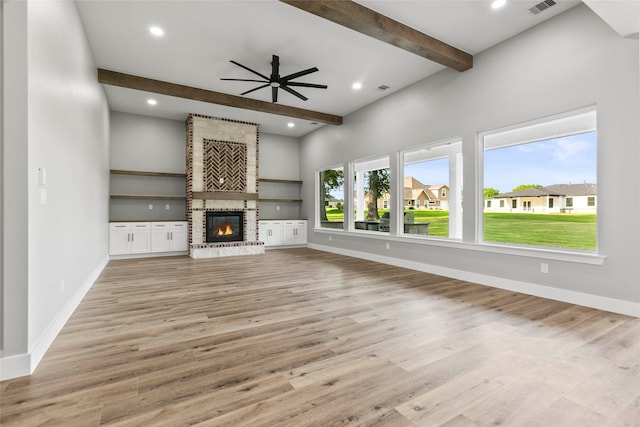 210 Hogan Ln, Hempstead, TX 77445 - unfurnished living room with beam ceiling, ceiling fan, a fireplace, light wood-type flooring, and recessed lighting