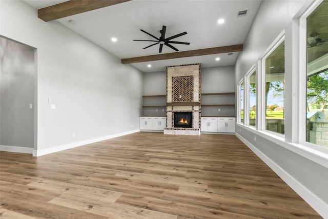 210 Hogan Ln, Hempstead, TX 77445 - unfurnished living room with beamed ceiling, wood finished floors, a brick fireplace, a ceiling fan, and recessed lighting