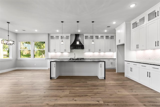 210 Hogan Ln, Hempstead, TX 77445 - kitchen featuring wall chimney exhaust hood, dark countertops, backsplash, recessed lighting, and wood finished floors