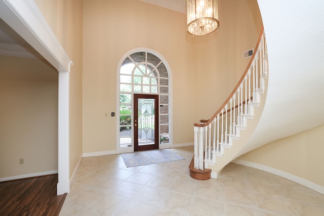 9327 Tranquil Park Dr, Spring, TX 77379 - entryway with a towering ceiling, a chandelier, stairway, crown molding, and tile patterned floors