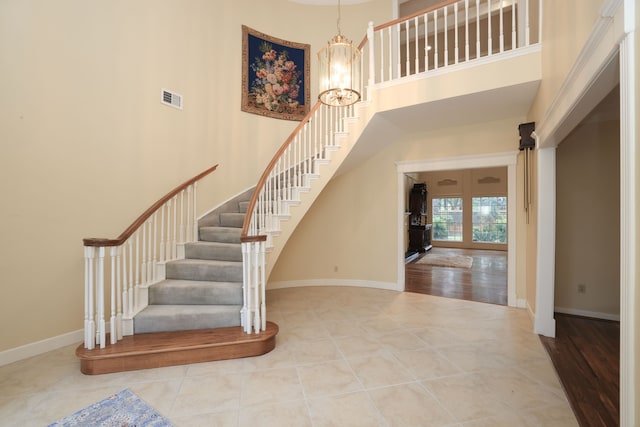 9327 Tranquil Park Dr, Spring, TX 77379 - staircase featuring a towering ceiling, tile patterned floors, a chandelier, and french doors