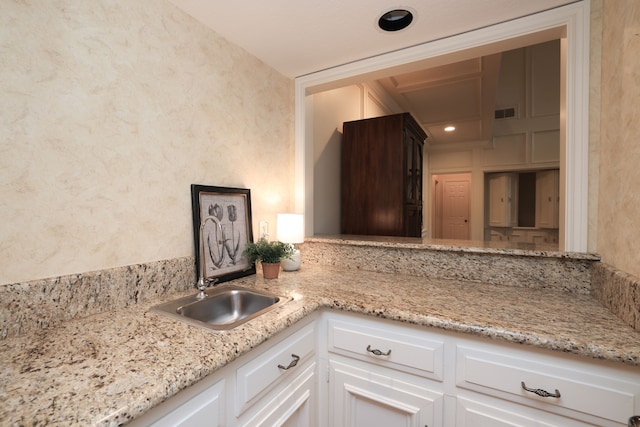 9327 Tranquil Park Dr, Spring, TX 77379 - kitchen with white cabinets, light stone counters, and a textured wall