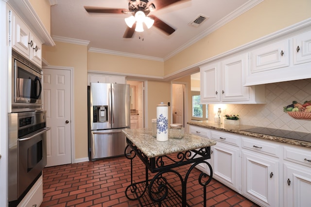 9327 Tranquil Park Dr, Spring, TX 77379 - kitchen with appliances with stainless steel finishes, brick flooring, ornamental molding, white cabinetry, and decorative backsplash