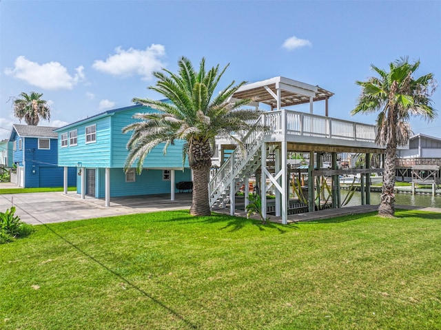 34 Tarpon Ln, Freeport, TX 77541 - back of property featuring stairway, a yard, concrete driveway, and a wooden deck