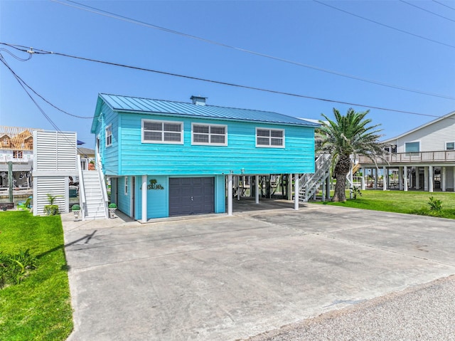 34 Tarpon Ln, Freeport, TX 77541 - coastal home with stairs, a garage, a carport, driveway, and a metal roof