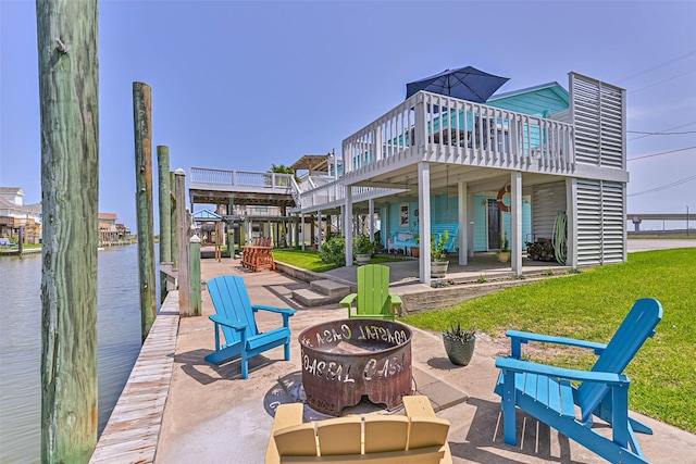 34 Tarpon Ln, Freeport, TX 77541 - rear view of house featuring a fire pit, a yard, a water view, and a patio