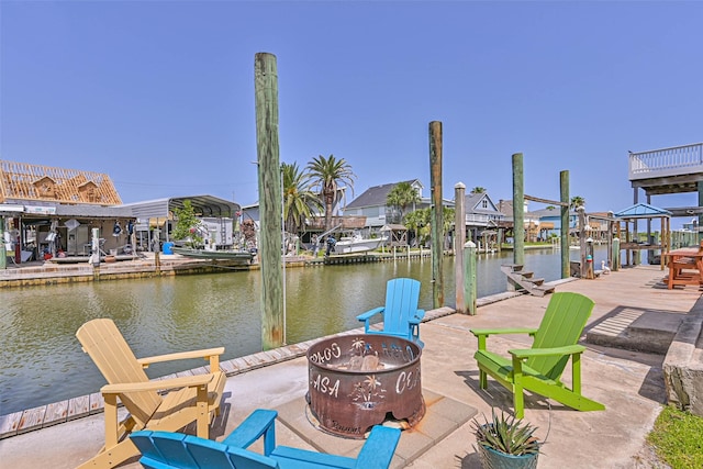 34 Tarpon Ln, Freeport, TX 77541 - dock area featuring boat lift, a fire pit, and a water view