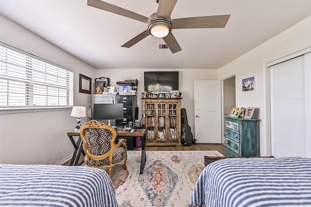 34 Tarpon Ln, Freeport, TX 77541 - bedroom with wood finished floors, a desk, and a ceiling fan