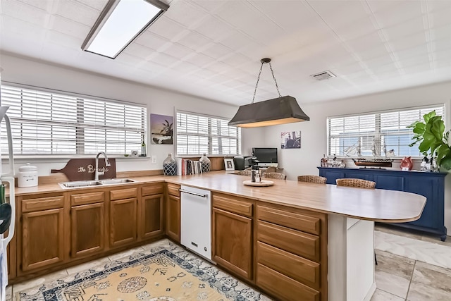 34 Tarpon Ln, Freeport, TX 77541 - kitchen featuring a peninsula, light countertops, dishwasher, and brown cabinets
