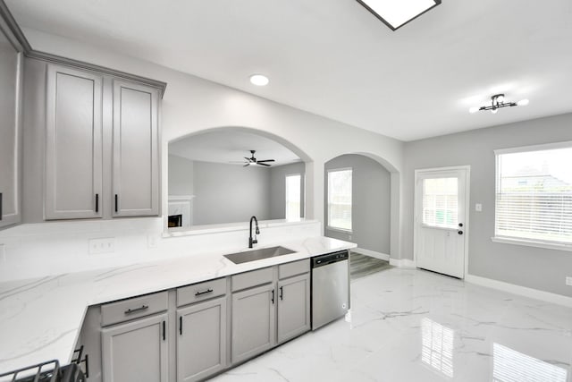 7427 Oakwood Canyon Dr, Cypress, TX 77433 - kitchen with gray cabinetry, stainless steel dishwasher, arched walkways, ceiling fan, and plenty of natural light