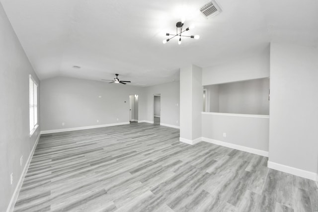 7427 Oakwood Canyon Dr, Cypress, TX 77433 - unfurnished living room with light wood finished floors, a chandelier, vaulted ceiling, and ceiling fan