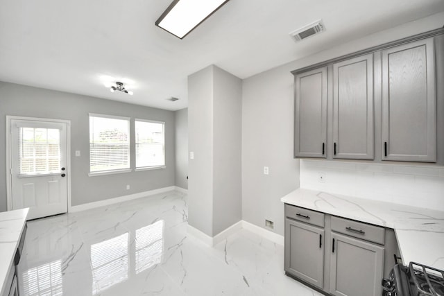 7427 Oakwood Canyon Dr, Cypress, TX 77433 - kitchen featuring gray cabinetry, light marble finish flooring, light stone counters, and tasteful backsplash
