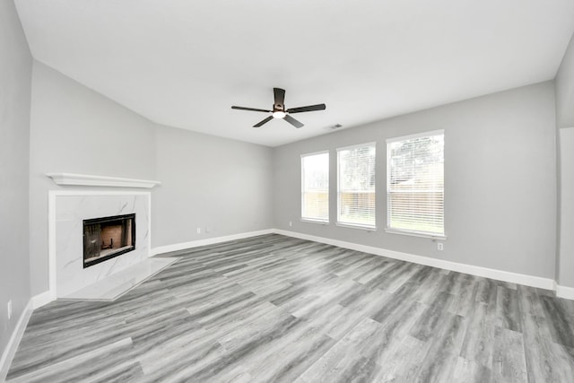 7427 Oakwood Canyon Dr, Cypress, TX 77433 - unfurnished living room featuring ceiling fan, wood finished floors, and a premium fireplace