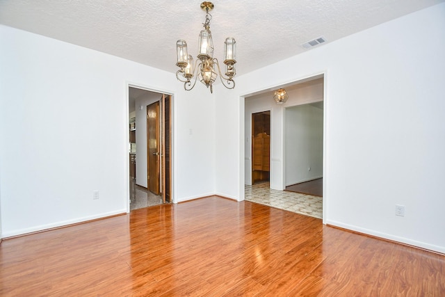 2622 Williams Grant St, Sugar Land, TX 77479 - spare room with a chandelier, wood finished floors, and a textured ceiling