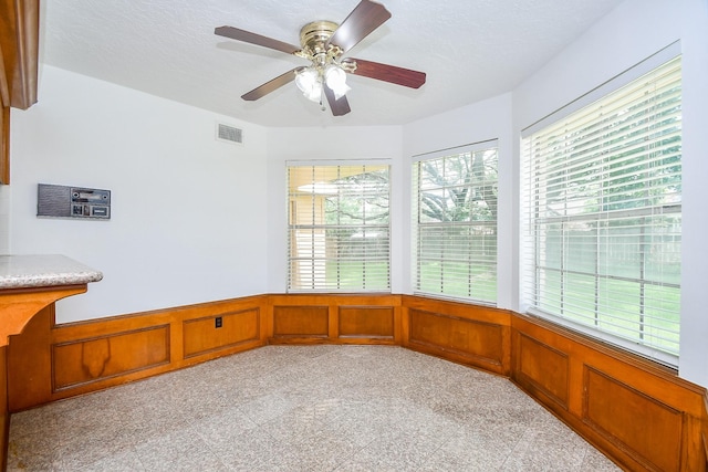 2622 Williams Grant St, Sugar Land, TX 77479 - unfurnished room with a decorative wall, granite floors, wainscoting, and ceiling fan