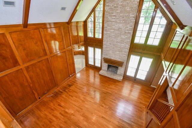 2622 Williams Grant St, Sugar Land, TX 77479 - unfurnished living room with wood finished floors, healthy amount of natural light, a fireplace, high vaulted ceiling, and beam ceiling