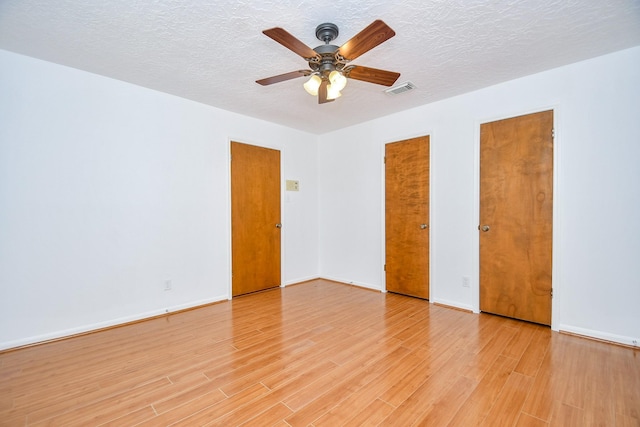 2622 Williams Grant St, Sugar Land, TX 77479 - unfurnished bedroom with light wood-style flooring, multiple closets, a textured ceiling, and ceiling fan