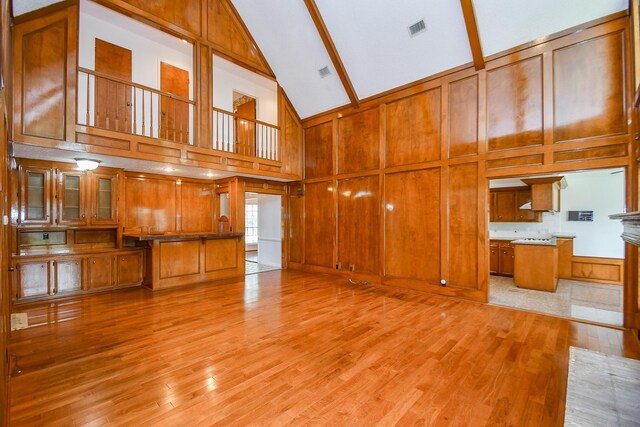 2622 Williams Grant St, Sugar Land, TX 77479 - unfurnished living room featuring high vaulted ceiling, light wood-style flooring, beamed ceiling, and wood walls