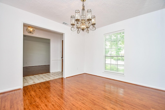 2622 Williams Grant St, Sugar Land, TX 77479 - empty room with a chandelier, plenty of natural light, a textured ceiling, and wood finished floors